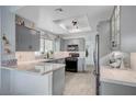 Updated kitchen with gray cabinets, white marble countertops, tile backsplash and stainless steel appliances at 8525 Festival Dr, Las Vegas, NV 89134