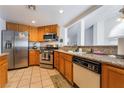 Well-lit kitchen features stainless steel appliances, granite countertops, and honey-colored wood cabinetry at 988 Flapjack Dr, Henderson, NV 89014