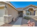 Inviting front entrance with stone accents, desert landscaping, and a well-lit walkway at 10212 Donald Weese Ct, Las Vegas, NV 89129