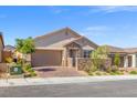 Charming single-story home featuring desert landscaping, stone accents, and a brick driveway on a sunny day at 10972 Nicholas Jay Ave, Las Vegas, NV 89166