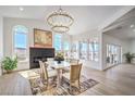 Elegant dining room with large windows, chandelier, fireplace, and seating for six at 1144 Calico Ridge Dr, Henderson, NV 89011