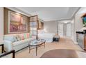 Cozy living area with sofa, glass coffee table, and kitchenette; artwork adds a stylish touch at 145 E Harmon Ave # 3801&3803, Las Vegas, NV 89109