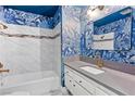 Stylishly designed bathroom with blue patterned wallpaper and marble tiled shower and backsplash at 1655 E Hacienda Ave, Las Vegas, NV 89119