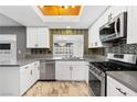Well-lit kitchen with white cabinets, stainless steel appliances, and modern backsplash at 1655 E Hacienda Ave, Las Vegas, NV 89119