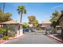 Gated community entrance with tiled roof guardhouse and lush landscaping at 2606 S Durango Dr # 122, Las Vegas, NV 89117