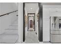 Elegant hallway with marble stairs, stainless steel fridge, dark accents, and views leading to an arched entryway at 30 Via Vasari # 102, Henderson, NV 89011