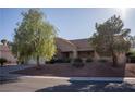 Single-story home showcasing desert landscaping and a tile roof, complemented by mature trees and a two-car garage at 3105 Birch Hill Ct, Las Vegas, NV 89134