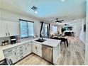Bright modern kitchen featuring white cabinetry, stainless steel appliances, tile backsplash and breakfast bar at 3194 Lapis Beach Dr, Las Vegas, NV 89117