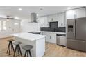 Modern kitchen features stainless steel appliances, sleek white cabinets, and an island with bar seating at 333 Rossmoyne Ave, North Las Vegas, NV 89030