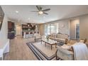 Open-concept living room and kitchen with wood flooring and stylish furnishings at 406 Gracious Way, Henderson, NV 89011