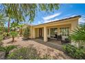An inviting covered patio with chairs, perfect for relaxing in the landscaped backyard at 4552 Largo Cantata St, Las Vegas, NV 89135