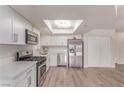 Bright kitchen featuring stainless steel appliances, white cabinets, and an updated light fixture at 4745 Madrigal Way, Las Vegas, NV 89122