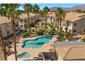 Inviting community pool with spa surrounded by palm trees and well maintained landscaping in Painted Desert at 4821 Black Bear Rd # 101, Las Vegas, NV 89149