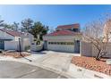 Low angle view of the home's facade, with a two-car garage and a front entrance gate at 5221 Crooked River Cir, Las Vegas, NV 89149