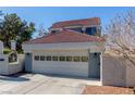 A view of the home's attached garage, with light colored doors, set amongst the neutral exterior of this property at 5221 Crooked River Cir, Las Vegas, NV 89149