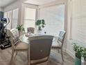 Bright breakfast nook with large sunny windows, gray dining chairs, and wood-look floors at 5422 Nestled Moon Ct, Las Vegas, NV 89131