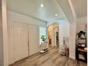 Spacious foyer with wood-look flooring, arched doorway, and modern decor at 5422 Nestled Moon Ct, Las Vegas, NV 89131