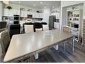 Open concept kitchen area with white cabinets, stainless steel appliances, and mirrored dining table at 5422 Nestled Moon Ct, Las Vegas, NV 89131