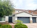 Two-story home featuring a tile roof, three-car garage, and manicured landscaping in a suburban neighborhood at 7020 Puetollano Dr, North Las Vegas, NV 89084