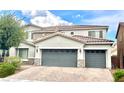 Two-story home featuring a tile roof, three-car garage, and manicured landscaping in a suburban neighborhood at 7020 Puetollano Dr, North Las Vegas, NV 89084