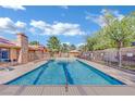 A community pool with clear blue water and lounge chairs next to a building with a stone chimney at 7200 Pirates Cove Rd # 1011, Las Vegas, NV 89145