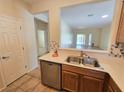 Open concept kitchen with stainless steel dishwasher and view to a naturally lit living room at 7957 Fantail Dr, North Las Vegas, NV 89084