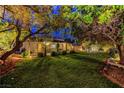 Backyard featuring a lush lawn, mature trees, and a covered patio perfect for outdoor entertaining at 853 Morning Sun Ct, Las Vegas, NV 89110