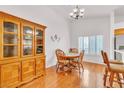 Bright dining area featuring hardwood floors, chandelier, and an adjacent breakfast bar at 930 High Plains Dr, Henderson, NV 89002