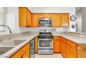 Efficient kitchen featuring oak cabinets, stainless steel appliances, and a double basin sink at 930 High Plains Dr, Henderson, NV 89002