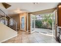 Light-filled dining room has tile floors, a glass back door, modern staircase, and warm tan walls at 10159 Tumbling Tree St, Las Vegas, NV 89183
