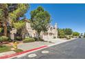 A side view of a two-story townhome with a landscaped yard and an attached two-car garage at 10159 Tumbling Tree St, Las Vegas, NV 89183