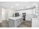 Modern kitchen with white cabinets, gray island, quartz countertops, and stainless steel appliances at 11273 Accademia Ct, Las Vegas, NV 89141