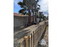 Backyard with palm trees and a partial fence, showcasing the lot's potential at 1655 N Gateway Rd, Las Vegas, NV 89115