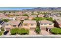 Aerial view of tan two-story homes showcasing the neighborhood, landscaping, and private driveways at 2544 Sable Ridge St, Henderson, NV 89044