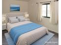 Bright bedroom featuring a queen bed with tufted headboard, soft blue accents, and a sunlit window at 2822 La Palma Dr, Laughlin, NV 89029