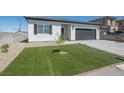 Inviting single-story home showcasing desert landscaping and a well-maintained lawn at 3440 Ernest St, North Las Vegas, NV 89032