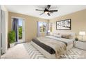 Serene main bedroom with a ceiling fan, plush carpeting, and a private outdoor balcony at 3619 Hat Rock Ct, Las Vegas, NV 89129