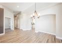 Bright living area with wood-look tile flooring, elegant chandelier, and neutral paint at 3882 Genoa Dr, Las Vegas, NV 89141