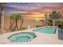 Relaxing backyard featuring a sparkling pool and spa surrounded by desert landscaping at 3882 Genoa Dr, Las Vegas, NV 89141
