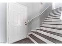 Inviting entryway features the front door, luxury vinyl plank flooring, and stairs with a modern handrail at 4321 Stockbridge St, Las Vegas, NV 89115