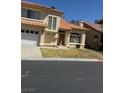 Stucco home with a two-car garage, red tile roof, and manicured front yard on a sunny day at 5024 Saint Annes Dr, Las Vegas, NV 89149
