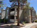 Exterior of multi-story condo showcasing neutral colors, balconies, and manicured landscaping at 555 E Silverado Ranch Blvd # 2052, Las Vegas, NV 89183
