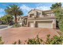Two-story home with neutral color palette, terracotta driveway and three-car garage is beautifully landscaped at 56 Grossinger Ct, Henderson, NV 89074