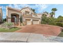 Charming two-story home with a three-car garage and terracotta driveway offers curb appeal at 56 Grossinger Ct, Henderson, NV 89074