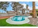 Beautiful kidney-shaped pool with a small waterfall feature, surrounded by a well-maintained backyard at 5757 Charles Holden Ct, Las Vegas, NV 89103