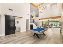 Expansive living room with a soaring ceiling, billiard table, staircase, and modern flooring at 6315 Bellisima St, Las Vegas, NV 89118