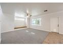 Bright living room with neutral carpet, large window, and ceiling fan, ready for personalized touches at 6649 Maple Mesa St, North Las Vegas, NV 89084