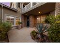Welcoming front entrance featuring a brick facade, well-placed plants, and a lovely wreath on the door at 7438 Desertscape Ave, Las Vegas, NV 89178