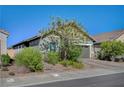 Beautiful home exterior with desert landscaping, a brick driveway and a welcoming curb appeal at 76 Summer Rhapsody Ave, Henderson, NV 89015