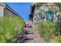 Inviting walkway with desert landscaping and charming chair at 76 Summer Rhapsody Ave, Henderson, NV 89015
